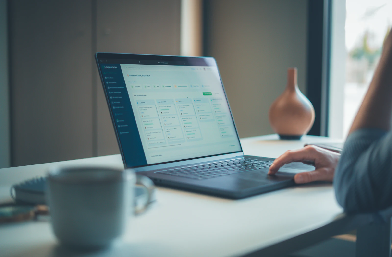 Person using a laptop at a bright workspace